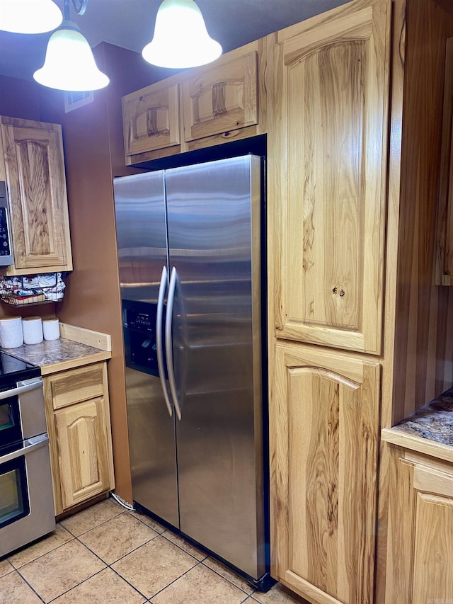 kitchen featuring light brown cabinets, light tile patterned floors, and stainless steel appliances