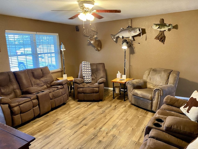 living room featuring ceiling fan and light hardwood / wood-style floors