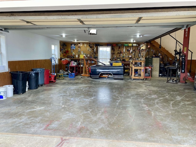 garage with a workshop area and wooden walls