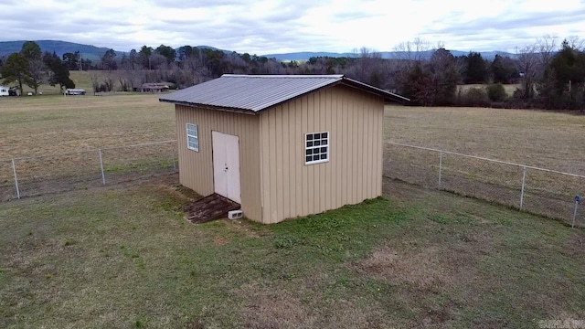 view of outdoor structure featuring a mountain view, a rural view, and a lawn