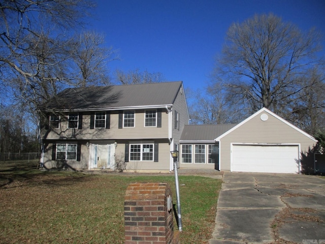 colonial-style house featuring a front yard and a garage