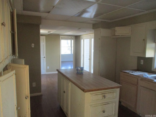 kitchen with cream cabinetry, a center island, and dark hardwood / wood-style floors