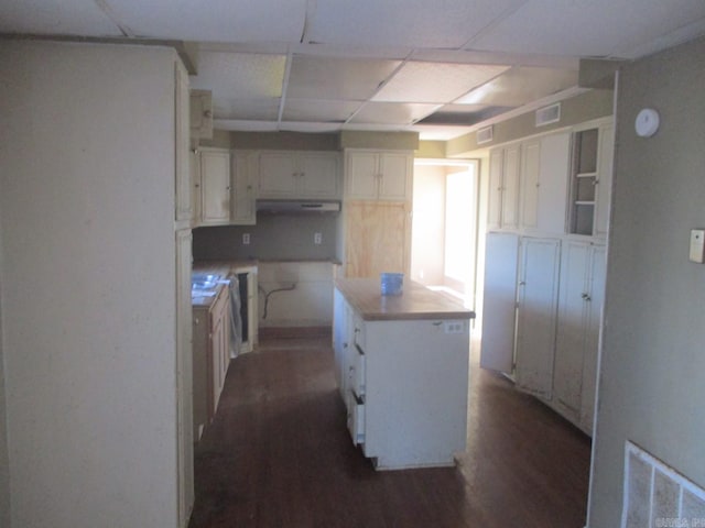 kitchen featuring white cabinets, a center island, dark hardwood / wood-style floors, and extractor fan