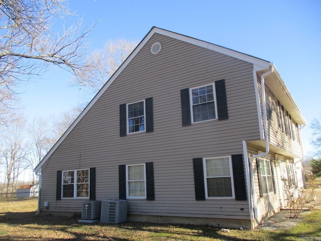 back of house featuring a yard and central AC unit