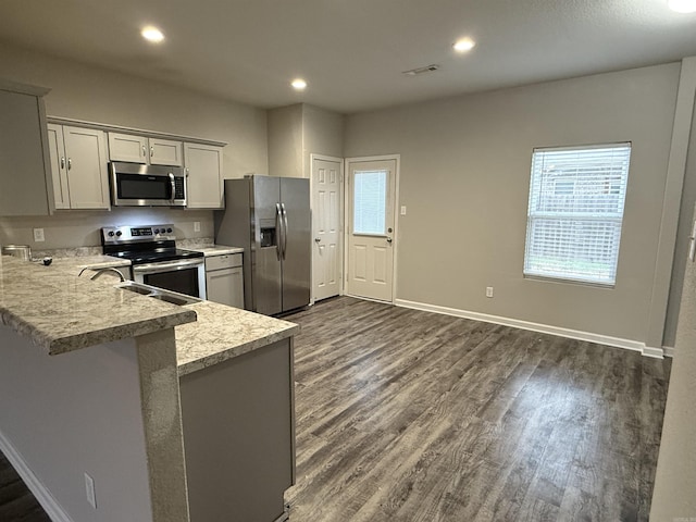 kitchen with gray cabinetry, sink, dark wood-type flooring, stainless steel appliances, and kitchen peninsula