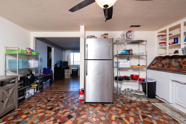 kitchen with white cabinetry, stainless steel fridge, ceiling fan, and a textured ceiling