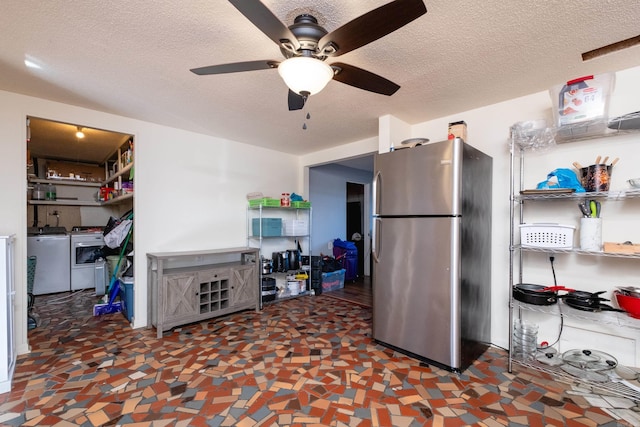 kitchen with ceiling fan, stainless steel fridge, separate washer and dryer, and a textured ceiling