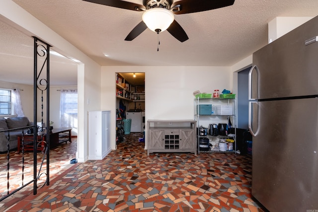 kitchen with ceiling fan, stainless steel fridge, and a textured ceiling