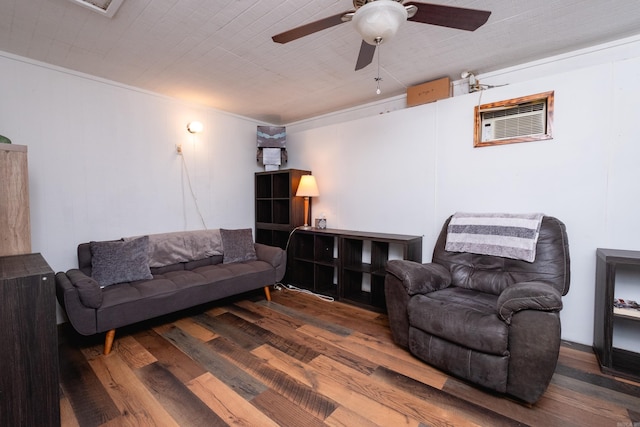 living room with a wall unit AC, ceiling fan, crown molding, and dark wood-type flooring