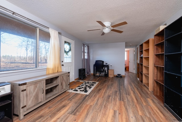 interior space featuring ceiling fan, a textured ceiling, and dark wood-type flooring