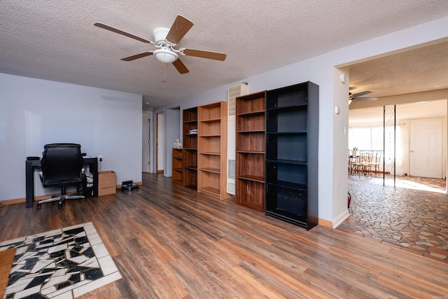 home office with ceiling fan, a textured ceiling, and dark wood-type flooring