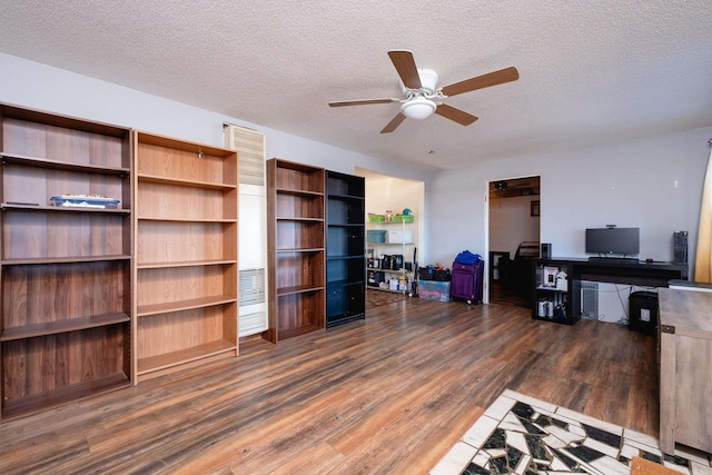 living room with ceiling fan, dark wood-type flooring, and a textured ceiling