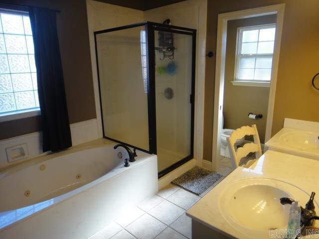 bathroom with tile patterned floors, vanity, plus walk in shower, and a healthy amount of sunlight