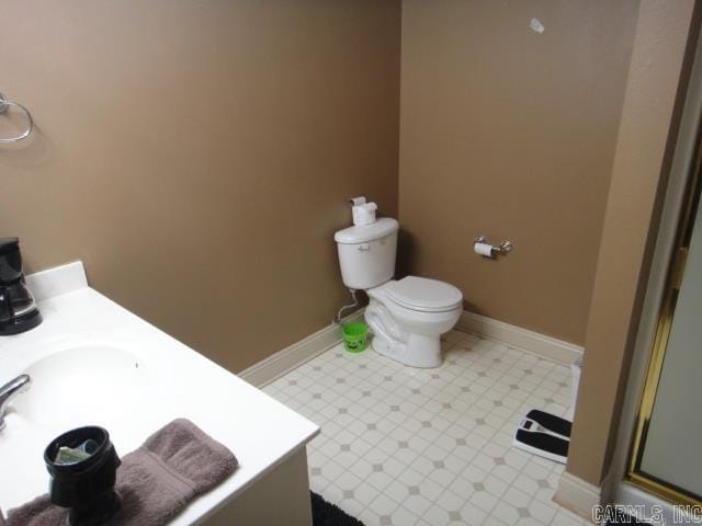 bathroom featuring vanity, toilet, and a shower with door