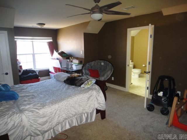 carpeted bedroom with ceiling fan and ensuite bathroom