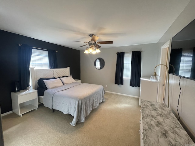 bedroom featuring light carpet, multiple windows, and ceiling fan