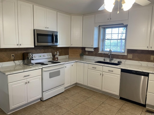 kitchen with sink, ceiling fan, light tile patterned floors, white cabinetry, and stainless steel appliances