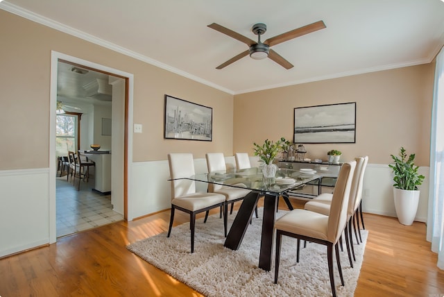 dining room with light hardwood / wood-style floors, ceiling fan, and crown molding