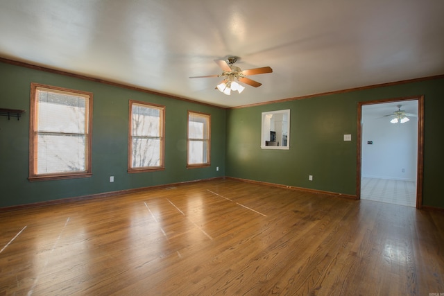 spare room with wood-type flooring, ceiling fan, and crown molding