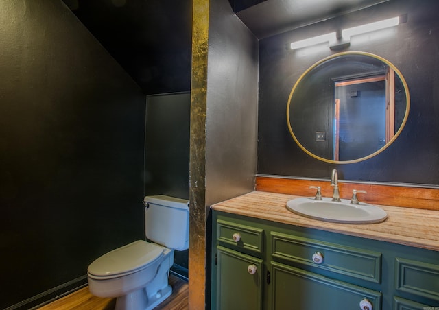 bathroom with hardwood / wood-style floors, vanity, and toilet