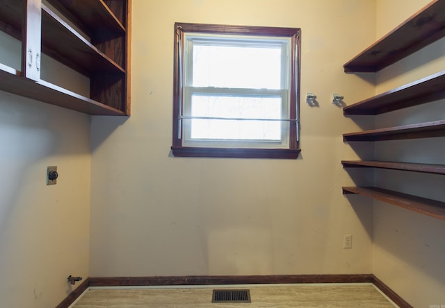 laundry area featuring hookup for an electric dryer and hardwood / wood-style flooring