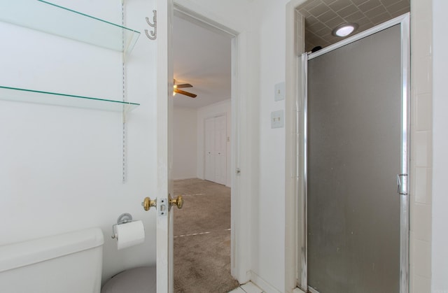 bathroom with ceiling fan, an enclosed shower, and toilet