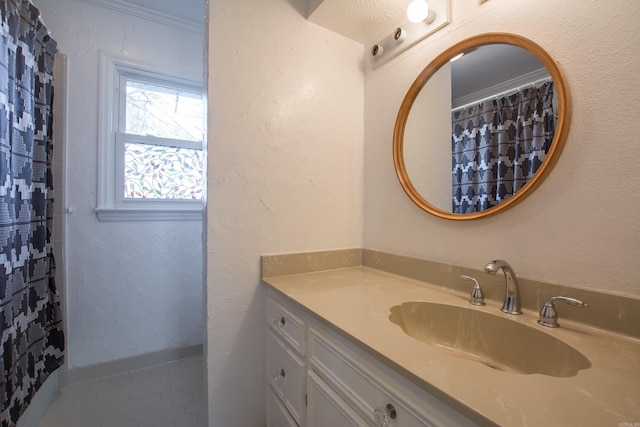 bathroom with crown molding, tile patterned flooring, and vanity