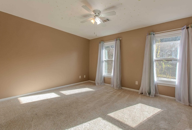 carpeted spare room with ceiling fan and a wealth of natural light