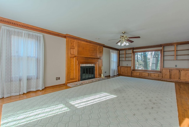 unfurnished living room with ceiling fan and ornamental molding