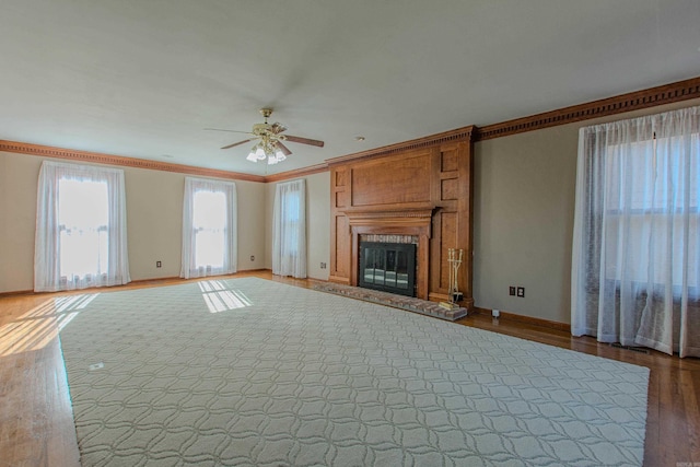 unfurnished living room with ceiling fan, wood-type flooring, and crown molding