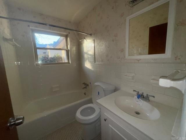 full bathroom with tile patterned flooring, vanity, tiled shower / bath combo, and toilet