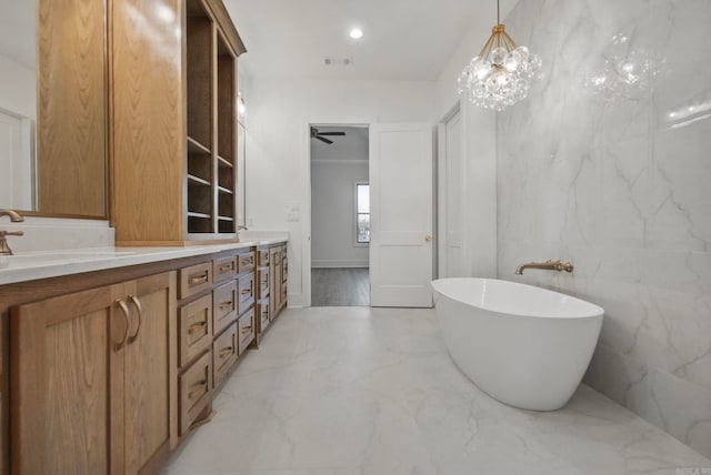 bathroom with a tub to relax in, ceiling fan, vanity, and tile walls