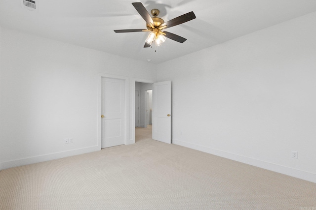 spare room with ceiling fan and light colored carpet