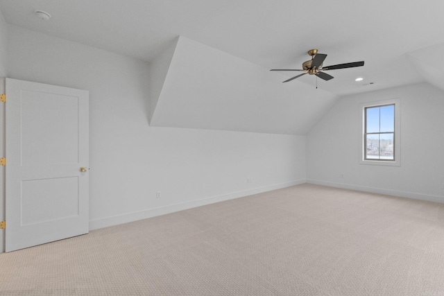 additional living space with ceiling fan, light colored carpet, and vaulted ceiling