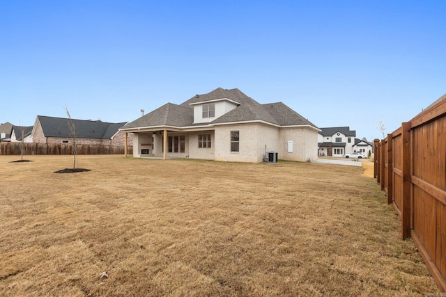 rear view of property with a yard and central air condition unit