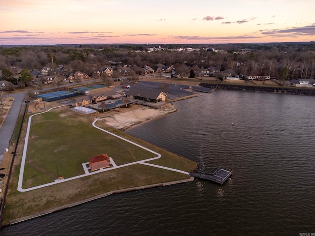 aerial view at dusk featuring a water view