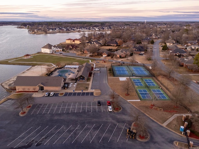 aerial view at dusk featuring a water view