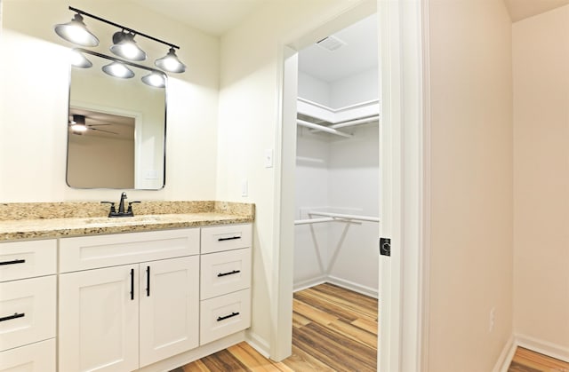 bathroom featuring ceiling fan, wood-type flooring, and vanity