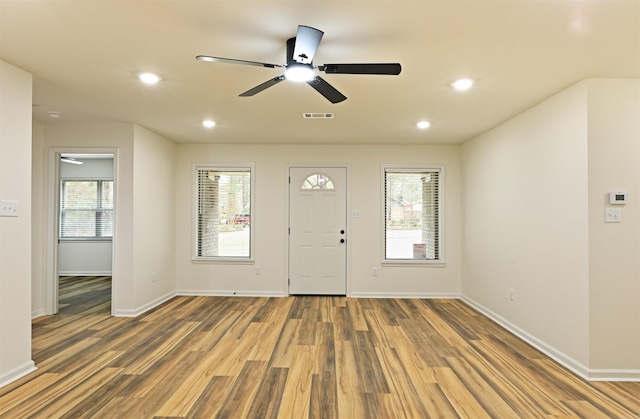 entrance foyer featuring hardwood / wood-style flooring, ceiling fan, and plenty of natural light