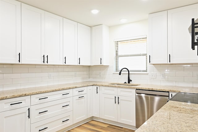 kitchen with dishwasher, decorative backsplash, white cabinets, and sink