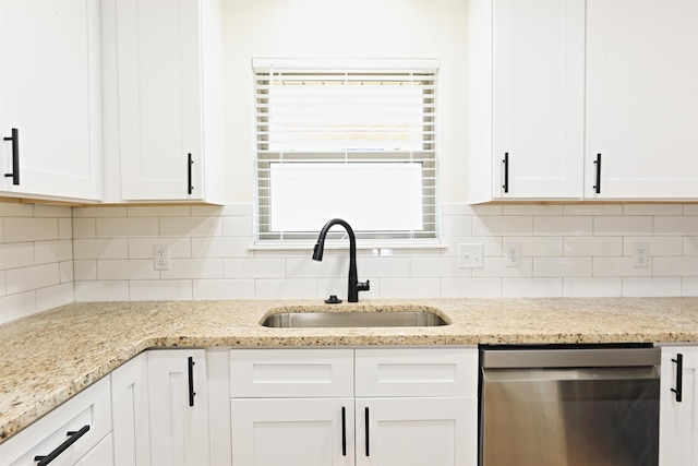 kitchen featuring decorative backsplash, white cabinetry, stainless steel dishwasher, and sink