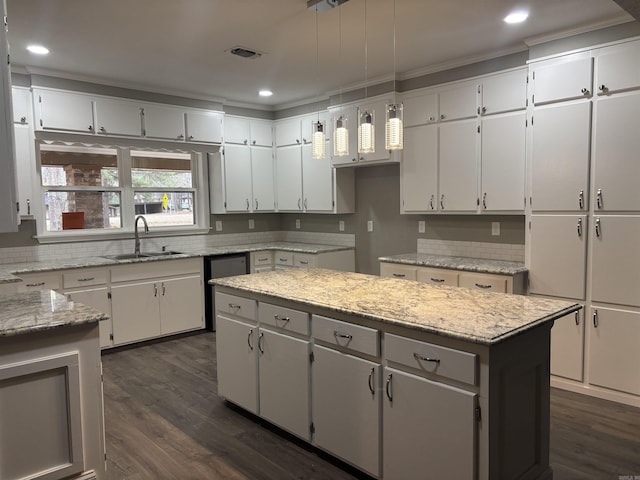 kitchen with white cabinets, sink, and a center island