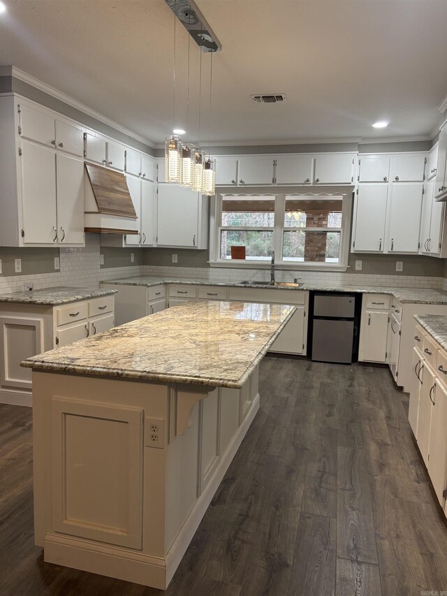 kitchen with white cabinetry, a center island, pendant lighting, and custom range hood