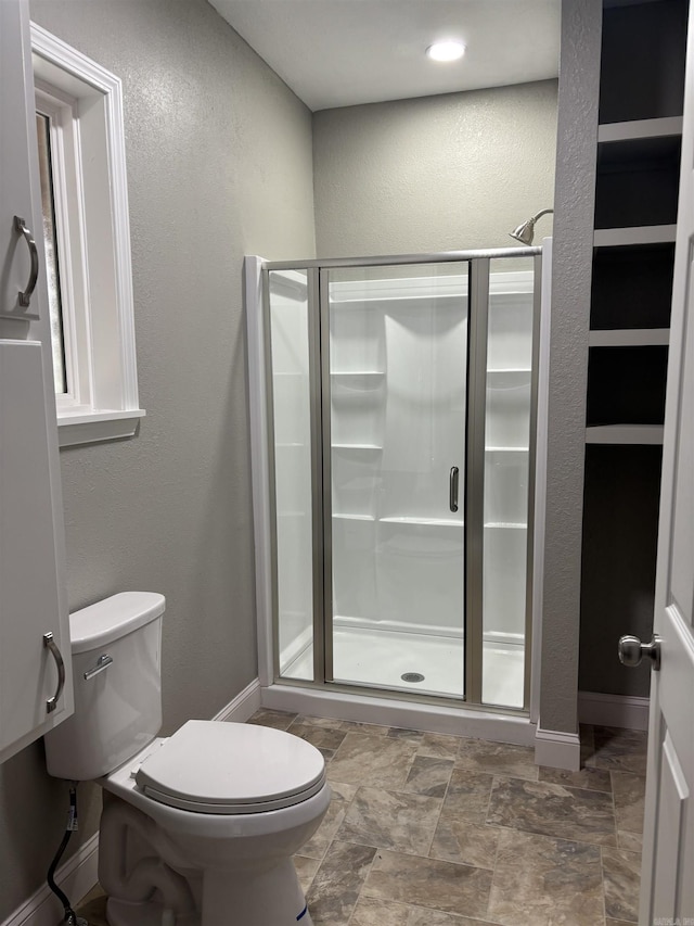 bathroom with toilet and a shower with shower door