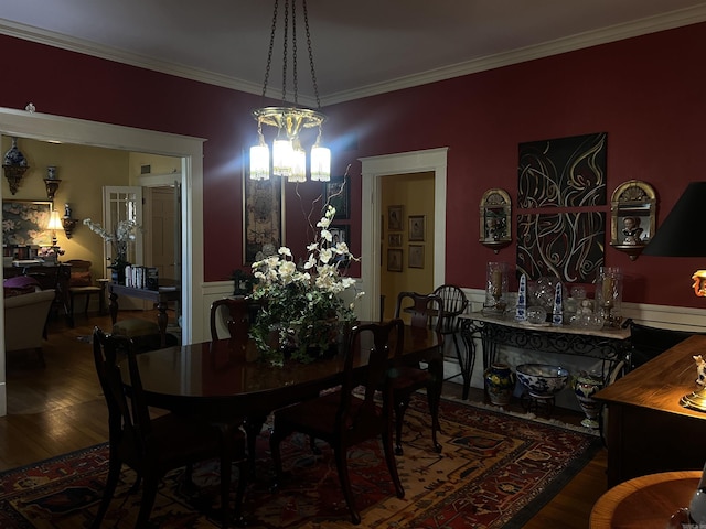 dining room featuring hardwood / wood-style floors, ornamental molding, and an inviting chandelier