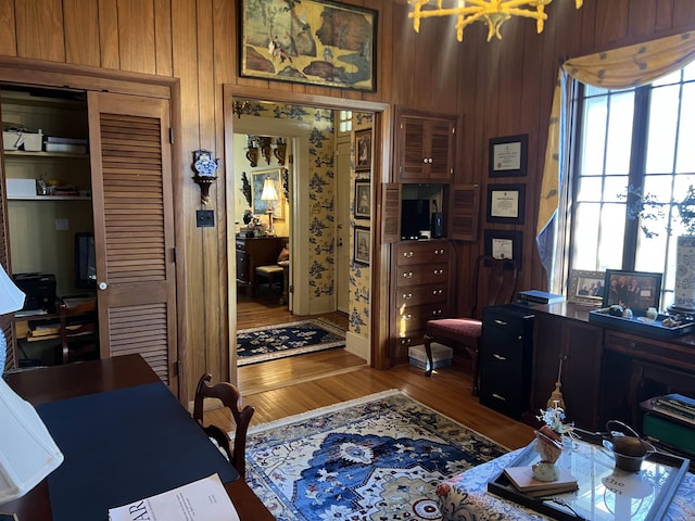 office with wooden walls and hardwood / wood-style flooring