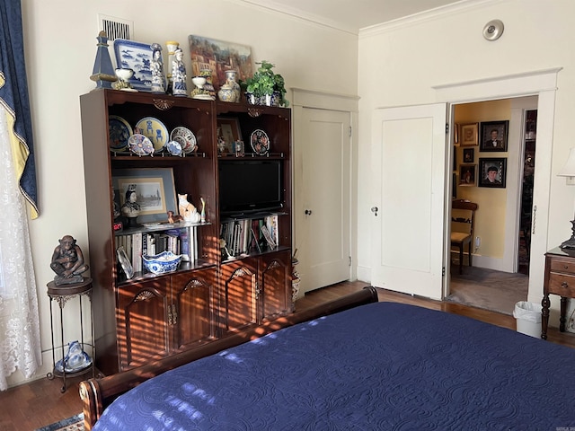 bedroom with wood-type flooring and ornamental molding