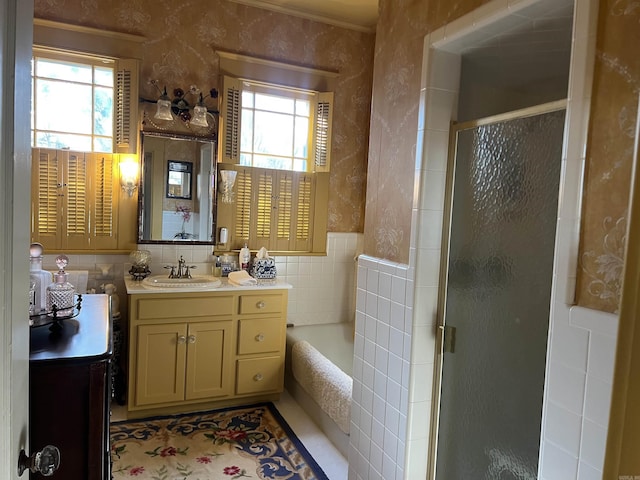 bathroom featuring vanity, separate shower and tub, and tile walls