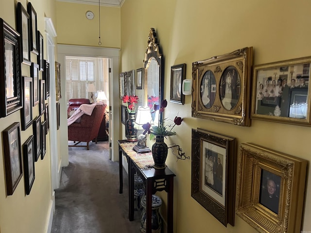 hall with dark carpet and ornamental molding