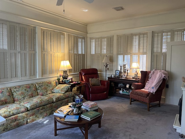 living room with ceiling fan, crown molding, and carpet